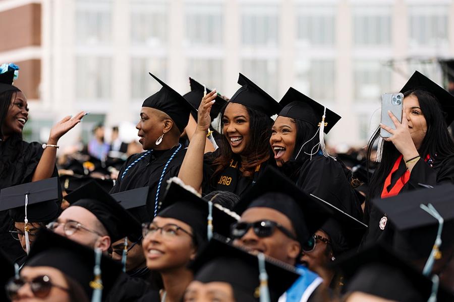 Graduating Students wearing graduation caps celebrating